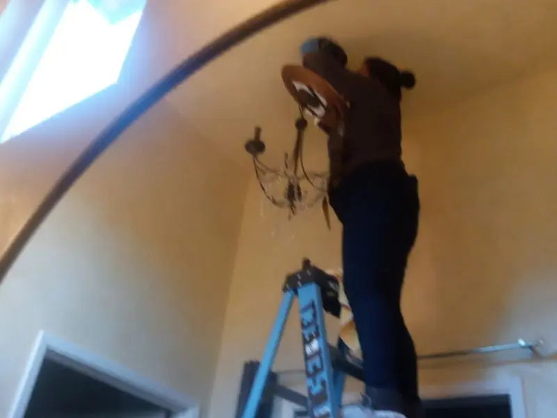 Electrician installing a chandelier in a Fairchild AFB residence