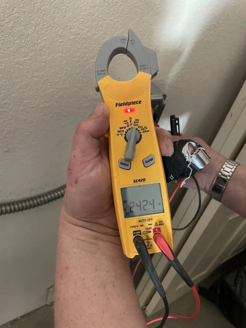 Voltage testing with clamp meter during Whole House Surge Protector in Fairchild AFB